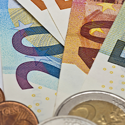 Das Bild zeigt mehrere Dokumente der Deutschen Rentenversicherung, die teilweise von Euro-Banknoten und Münzen bedeckt sind. Die Banknoten umfassen verschiedene Stückelungen, darunter 20- und 50-Euro-Scheine. Im Vordergrund sind auch einige Euro-Münzen zu sehen. Die Dokumente tragen den Aufdruck "Deutsche Rentenversicherung Bund".