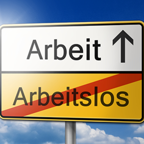 Das Bild zeigt ein Verkehrsschild vor einem blauen Himmel mit einigen Wolken. Das Schild ist in zwei Hälften unterteilt: Die obere Hälfte ist weiß und zeigt das Wort "Arbeit" mit einem Pfeil, der nach oben zeigt. Die untere Hälfte ist gelb und zeigt das durchgestrichene Wort "Arbeitslos".