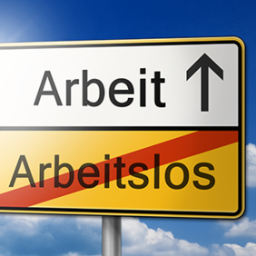 Das Bild zeigt ein Verkehrsschild vor einem blauen Himmel mit einigen Wolken. Das Schild ist in zwei Hälften unterteilt: Die obere Hälfte ist weiß und zeigt das Wort "Arbeit" mit einem Pfeil, der nach oben zeigt. Die untere Hälfte ist gelb und zeigt das durchgestrichene Wort "Arbeitslos". 